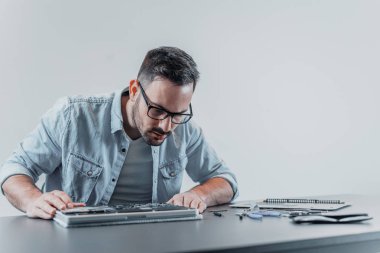Bilgisayar teknisyeni bakarak çözüm arayışı içinde laptop sökülmüş. Bilgisayar tamir kavramı