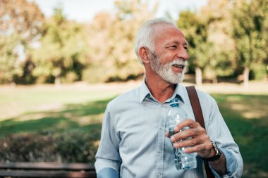 Şişe su Park ile olgun adam.