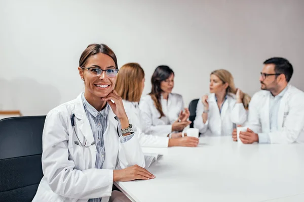 Bella Sorridente Medico Femminile Guardando Fotocamera Mentre Suoi Colleghi Sono — Foto Stock