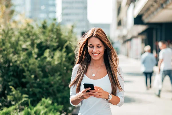 Mujer Joven Mensajes Texto Mientras Camina Calle Ciudad — Foto de Stock