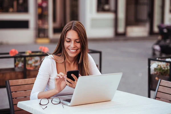 Portrait Smiling Young Woman Using Mobile Phone While Sitting Laptop — Stock Photo, Image