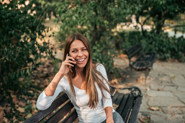 Attractive Smiling Girl Sitting Bench Park Talking Smart Phone — Stock Photo, Image