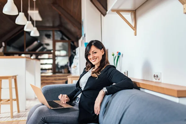 Retrato Una Mujer Morena Sonriente Usando Portátil Mientras Está Sentada —  Fotos de Stock