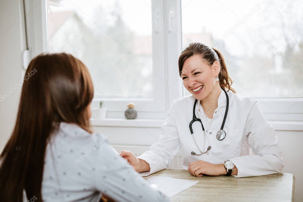 Smiling physician examining client in office.