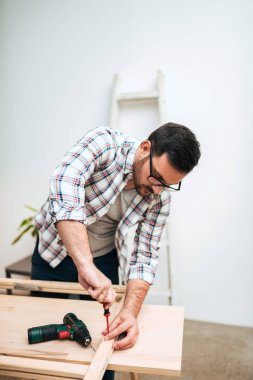 Ahşap içine bir vida vidalama el genç adam. DIY proje kavramı.