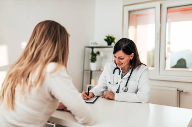 Güzel kadın doktor hastasını için form doldurma.