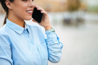 Genç işkadını smartphone açık havada üzerinde konuşuyor. Yakın çekim.