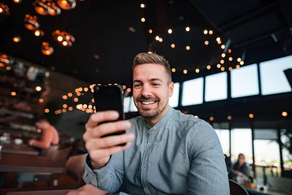 Joven Sonriente Usando Teléfono Inteligente Cafetería Moderna — Foto de Stock