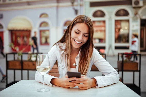 Unga Kvinnan Skrattar Medan Använder Telefonen Utomhus Restaurang — Stockfoto
