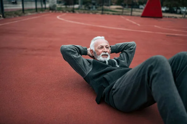 Active Senior Doing Sit Ups Outdoors — Stock Photo, Image