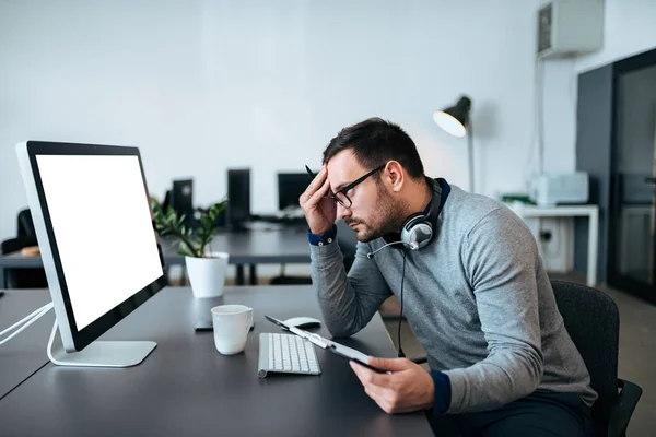 Concerned Customer Support Agent Looking His Monitor While Holding Files — Stock Photo, Image
