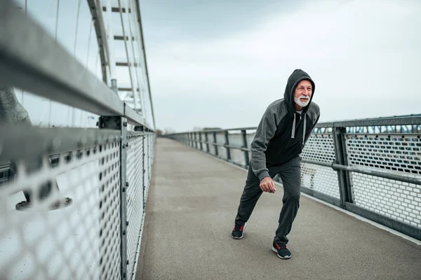 Uomo Anziano Forma Correre Attraverso Ponte Con Cappuccio — Foto Stock