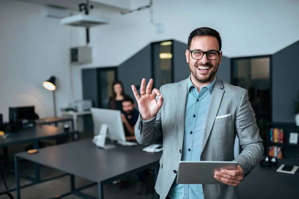 Bonito Jovem Empresário Mostrando Gesto Escritório Moderno Colegas Fundo — Fotografia de Stock