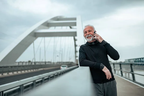 Active senior runner talking on the phone.