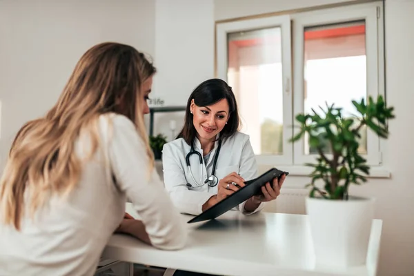 Junge Schöne Ärztin Lächelt Patientin Während Sie Sie Konsultiert — Stockfoto