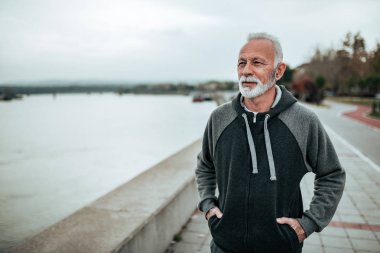 Şehrin Nehri yakınında yürüyüş bir üst düzey sporcu portresi.