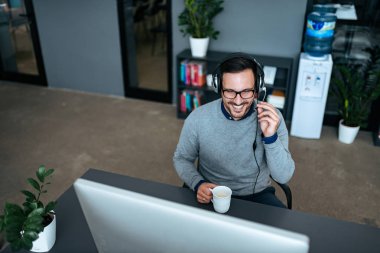 Yüksek açı imge-in yakışıklı teknik destek Yöneticisi bir istemci danışmanlık kulaklık.