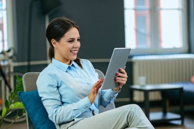 Gülümseyen işkadını kapalı dijital tablet kullanma.