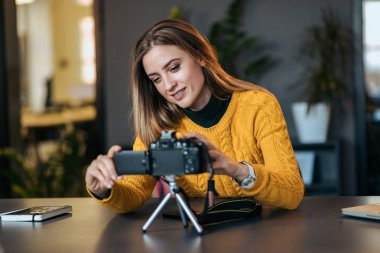 Genç kadın kamera vlogging için hazırlanıyor.