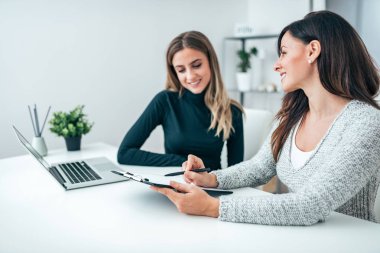 Birlikte parlak bir modern ofiste çalışan iki güzel kadın.