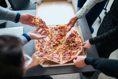 Dilim pizza yemek molası üzerinde bir el Close-Up.