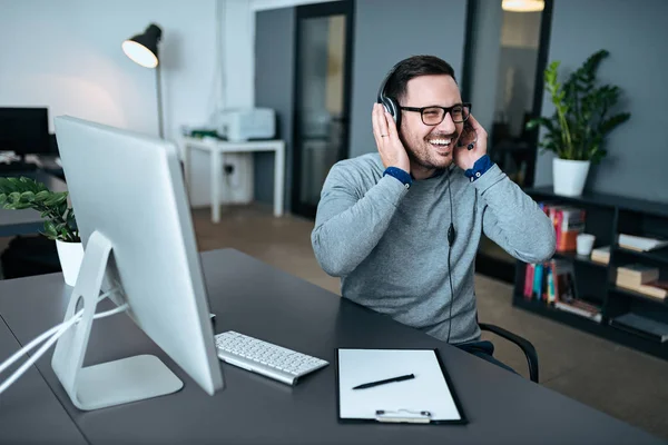 Casual Επιχειρηματίας Ακουστικά Μιλώντας Και Γελώντας Στο Σύγχρονο Γραφείο — Φωτογραφία Αρχείου