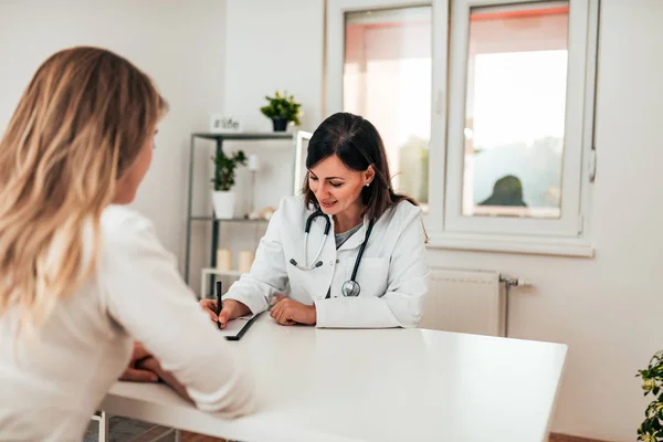 Vrouwelijke Specialist Het Neerschrijven Van Patiënten Symptomen — Stockfoto