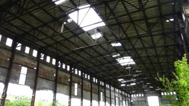 Eski bir fabrikanın kalıntıları. Terk edilmiş bina çimen ve ağaçlarla kaplıydı. Duvarlarda ve tavanda delikler ve çatlaklar.