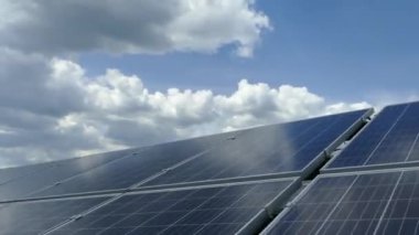 Güneş istasyonundaki güneş panelleri. Bulutlar güneş panellerinin yüzeyine yansıyor. Alternatif temiz elektrik. Polikristalize ve tek kristal elementler.