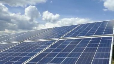 Güneş istasyonundaki güneş panelleri. Bulutlar güneş panellerinin yüzeyine yansıyor. Alternatif temiz elektrik. Polikristalize ve tek kristal elementler.