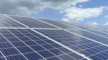 Güneş istasyonundaki güneş panelleri. Bulutlar güneş panellerinin yüzeyine yansıyor. Alternatif temiz elektrik. Polikristalize ve tek kristal elementler.