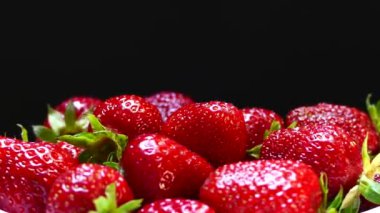 Siyah ve yeşil arka planda bir kasede taze ve olgun çilekler. Bahçelerinden çilekler geliyor. Kırmızı vitamin meyveleri