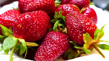 Siyah ve yeşil arka planda bir kasede taze ve olgun çilekler. Bahçelerinden çilekler geliyor. Kırmızı vitamin meyveleri