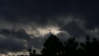 Güzel bulutlar sinek ve hızlı bir şekilde batımında gökyüzünde hareket. Siyah ve gri bulutlar fırtına öncesi sessizlik.