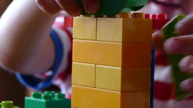 Çocuk masada bir plastik tasarımcıyla oynuyor. Oyuncaklarla mutlu ve tasasız bir çocukluk. Çocuk gelişimi.