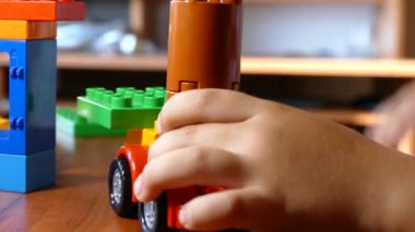 Çocuk masada bir plastik tasarımcıyla oynuyor. Oyuncaklarla mutlu ve tasasız bir çocukluk. Çocuk gelişimi.