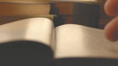 Bir adam kitap okur ve sayfaları karıştırır. Kütüphanede kitap okuyor. Bilimsel materyaller üzerine çalışıyorum. Arşive bakıyorum..