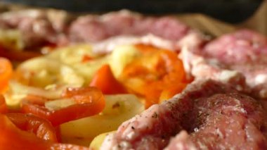 Bir tabak et ve sebze hazırla. Pişirmek için hazırlanmış sebzelerin üzerine bir parça çiğ et yavaşça bırakılır.. 