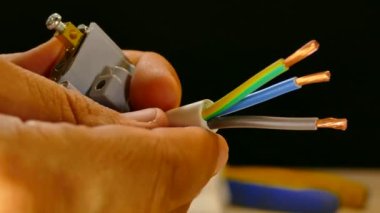 Elektrikçi elektrik tesisatı kuruyor. Kablolar ve elektrik prizleri. Prizler ve prizler. Bakır kablo ve zemin.