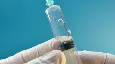 Doktor bir enjeksiyon şırınga hazırlanıyor. İlaç kullanıyor. Aşı. Enfeksiyon. Bölgede karantina.