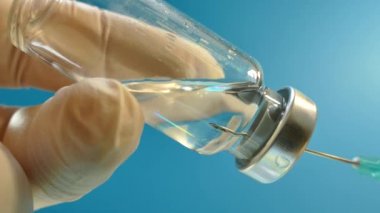 Doktor bir enjeksiyon şırınga hazırlanıyor. İlaç kullanıyor. Aşı. Enfeksiyon. Bölgede karantina.