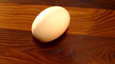 Tavuk yumurtası mutfak masasında dönüyor. Haşlanmış ya da çiğ yumurta elle açılmamış.. 