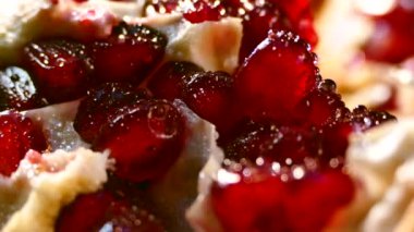 Nar meyvesi parçalara ayrılır. Nar tohumları bir tabakta yatıyor. Kesme tahtasında sulu kırmızı meyve. Güzel nar posası..