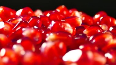 Nar meyvesi parçalara ayrılır. Nar tohumları bir tabakta yatıyor. Kesme tahtasında sulu kırmızı meyve. Güzel nar posası..