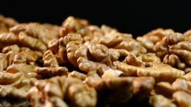 Ceviz portre. Fındık kabuğu siyah bir arka plan olmadan. Masanın üzerine dağılmış taneleri.