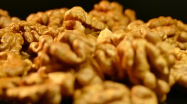 Ceviz portre. Fındık kabuğu siyah bir arka plan olmadan. Masanın üzerine dağılmış taneleri.