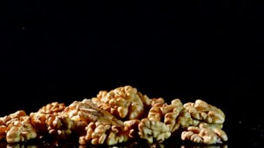 Ceviz portre. Fındık kabuğu siyah bir arka plan olmadan. Masanın üzerine dağılmış taneleri.