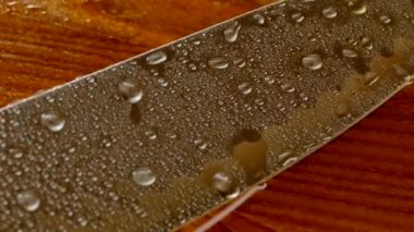 Şefin bıçak yakın çekim. Bıçak dövme. bıçak bıçak. Damla su akışı bir bıçak bıçak aşağı. Sebze kesme. Öğle yemeği yemek. Yansıma soğuk silahlar.