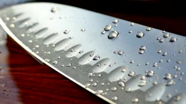 Şefin bıçak yakın çekim. Bıçak dövme. bıçak bıçak. Damla su akışı bir bıçak bıçak aşağı. Sebze kesme. Öğle yemeği yemek. Yansıma soğuk silahlar.