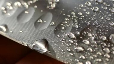 Şefin bıçak yakın çekim. Bıçak dövme. bıçak bıçak. Damla su akışı bir bıçak bıçak aşağı. Sebze kesme. Öğle yemeği yemek. Yansıma soğuk silahlar.